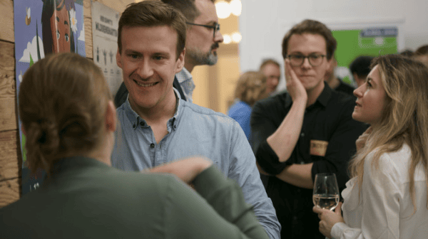 Gruppe von Personen bei einem Event mit GLOBAL 2000-Plakaten im Hintergrund