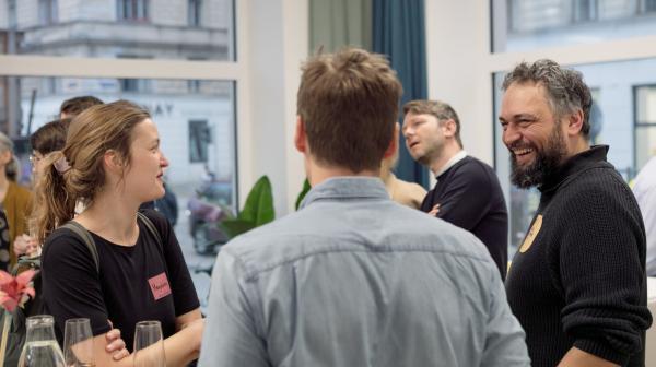 Gruppe von Personen bei einem geselligen Event von GLOBAL 2000 mit Getränken in den Händen