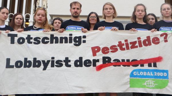 Aktivistinnen halten ein Banner hoch auf dem steht: Totschnig: Lobbyist der Pestizide?