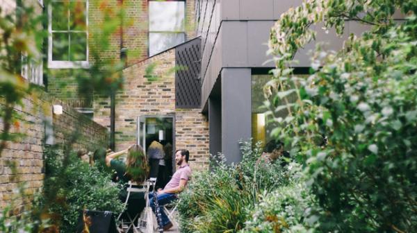 Menschen sitzen im Garten in der Stadt