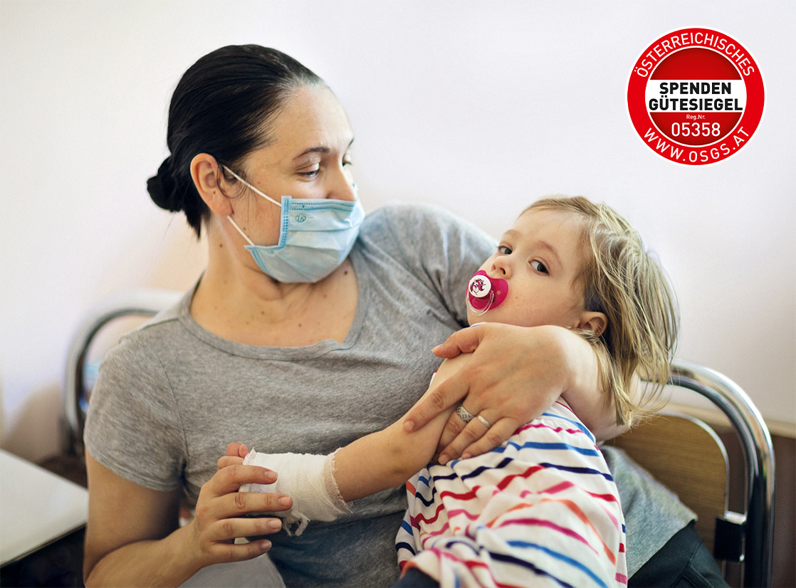 Tschernobylkind und Mutter mit Maske und Spendengütesiegel Tschernobylkind und Mutter mit Maske und Spendengütesiegel